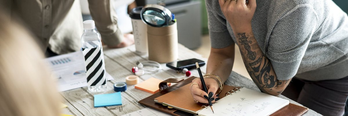 A small business owner writes in a planner.