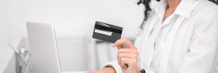 A smiling woman holds a credit card.