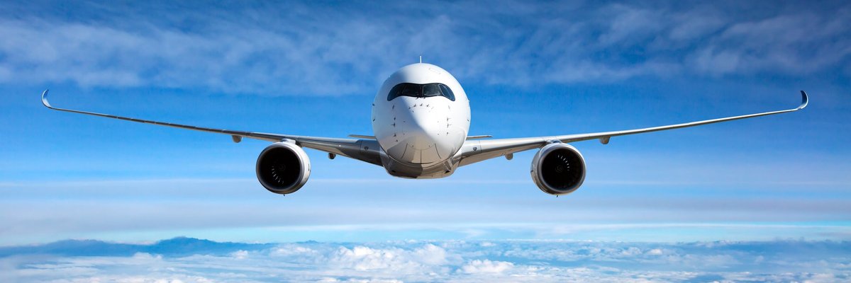 An airplane flying through blue skies.