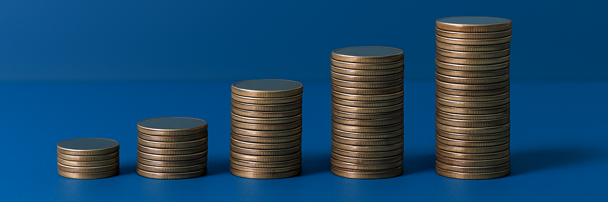Stacks of silver coins in increasing heights on a dark blue background.