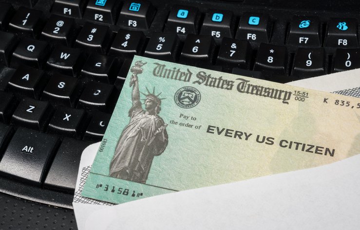 A stimulus check from the U.S. Treasury on a computer keyboard.