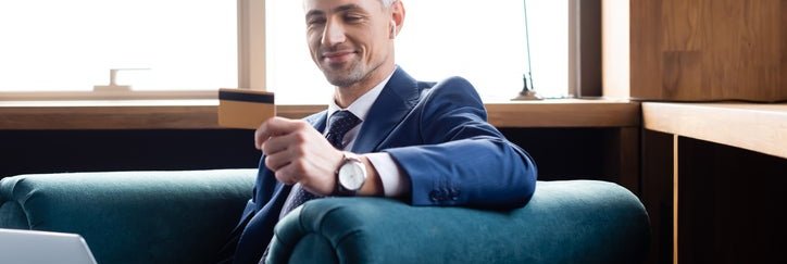 A man in a suit with his credit card.