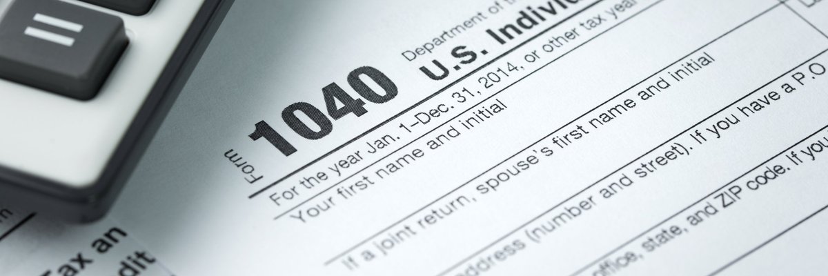 IRS tax form 1040 next to pen and calculator.