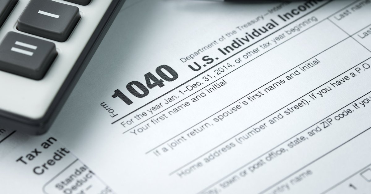 IRS tax form 1040 next to pen and calculator.