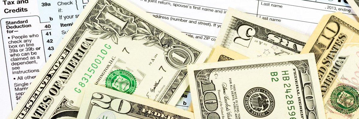 Various dollar bill amounts on top of tax forms.