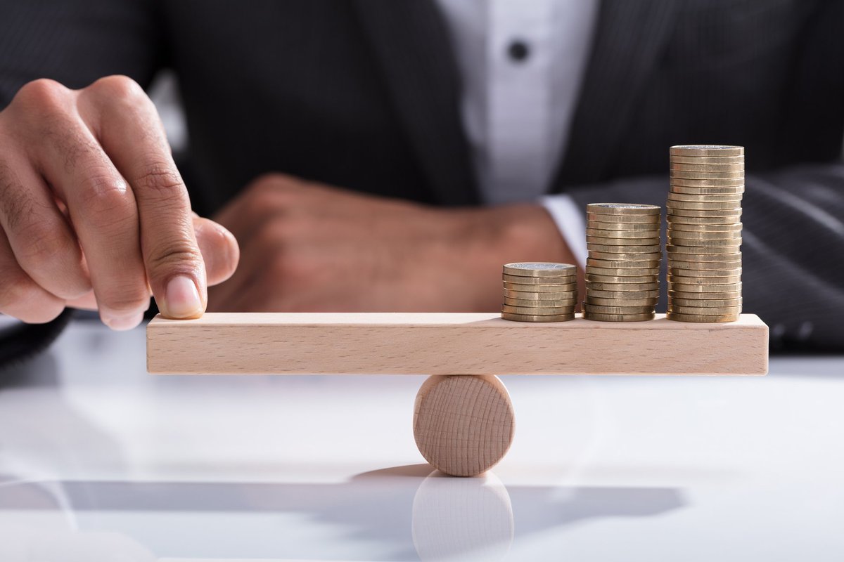 tipping a money scale with hand