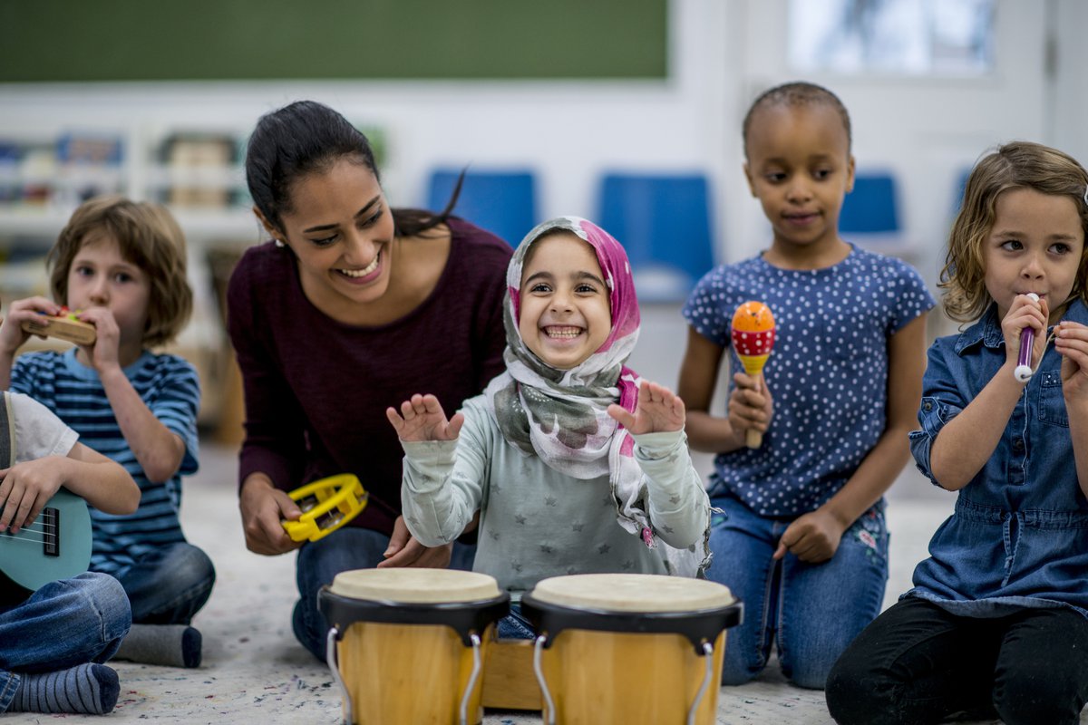 Young children having fun at daycare playing with instruments.