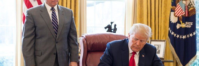 President Trump signing an executive order in the Oval Office.