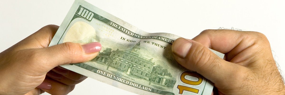 two hands pulling on $100 bill