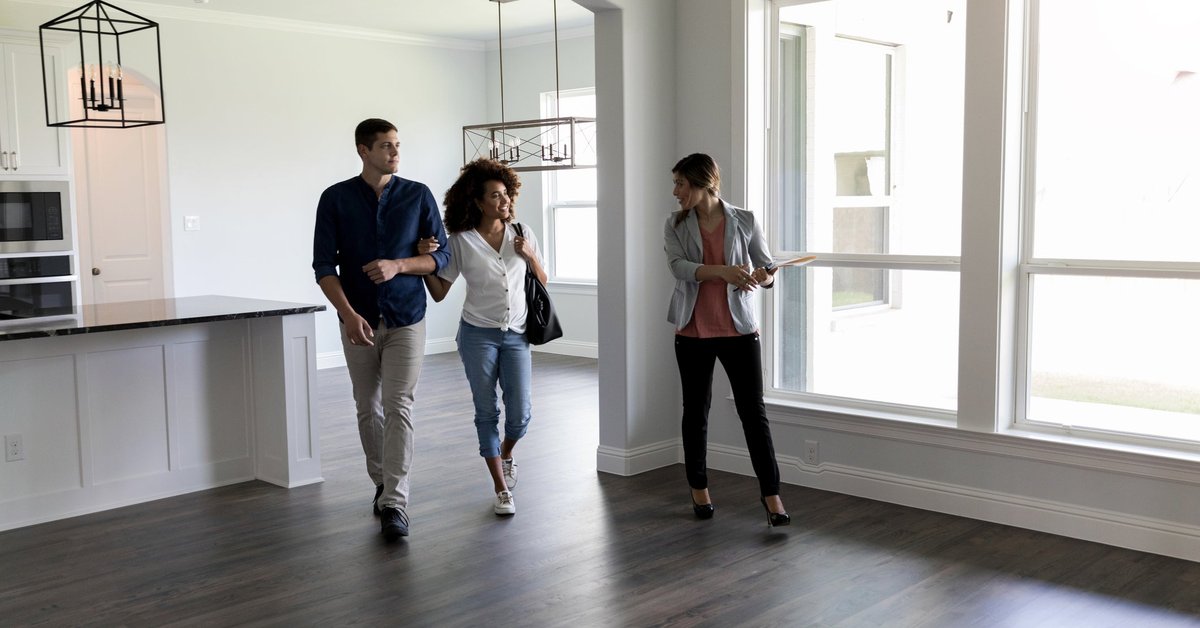 Two people viewing the interior of a house with a realtor.