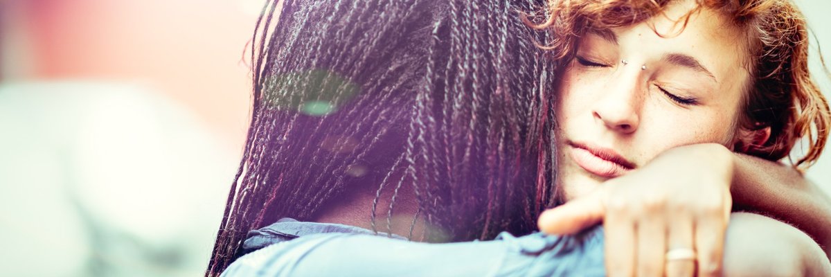 A young woman hugging her girlfriend.