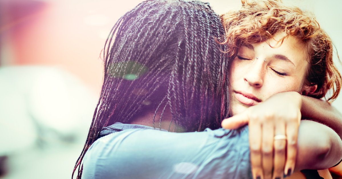 A young woman hugging her girlfriend.