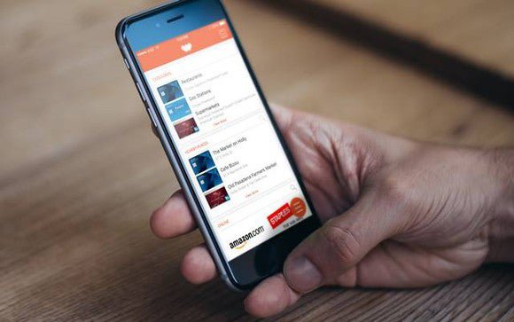 A man holding an iPhone with the Wallaby app open.
