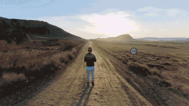 Transition from a man on a dirt road to a woman running in a field