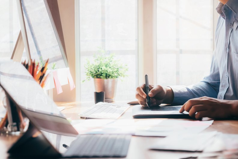 A web designer working in a sunny home office.