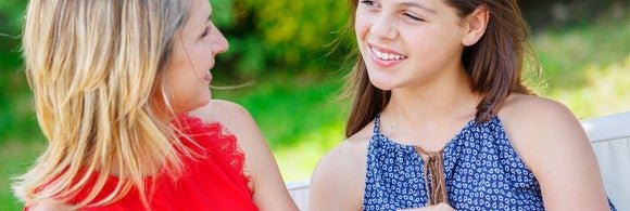 Woman handing teenage girl a credit card