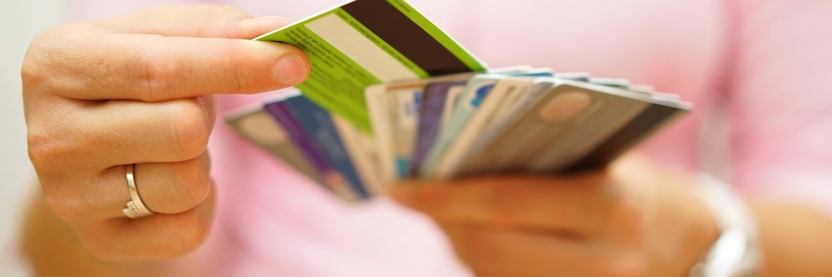 Woman choosing one credit card from a handful of many cards