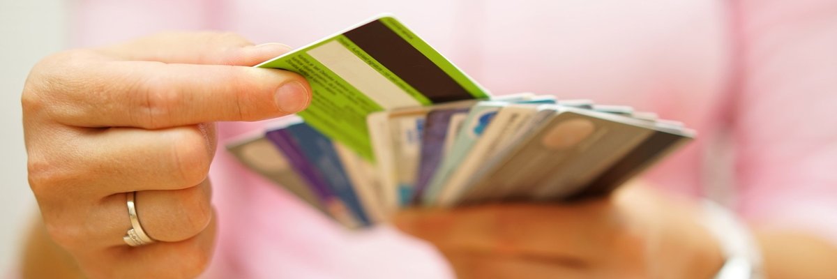 Woman choosing one credit card from a handful of many cards