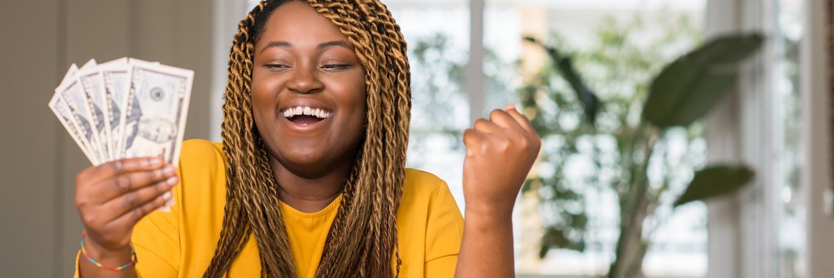 woman holding a handful of money and smiling