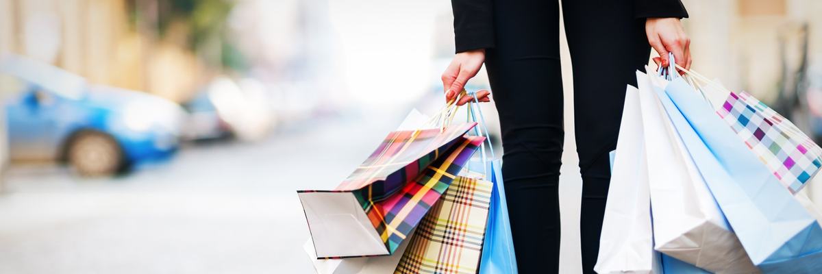 A woman holding a lot of shopping bags.