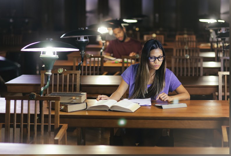A female college student studying in an almost-empty library.