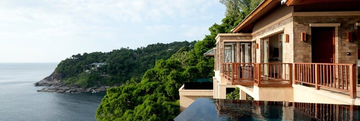 A woman in a pool at a luxury hotel overlooking the ocean.