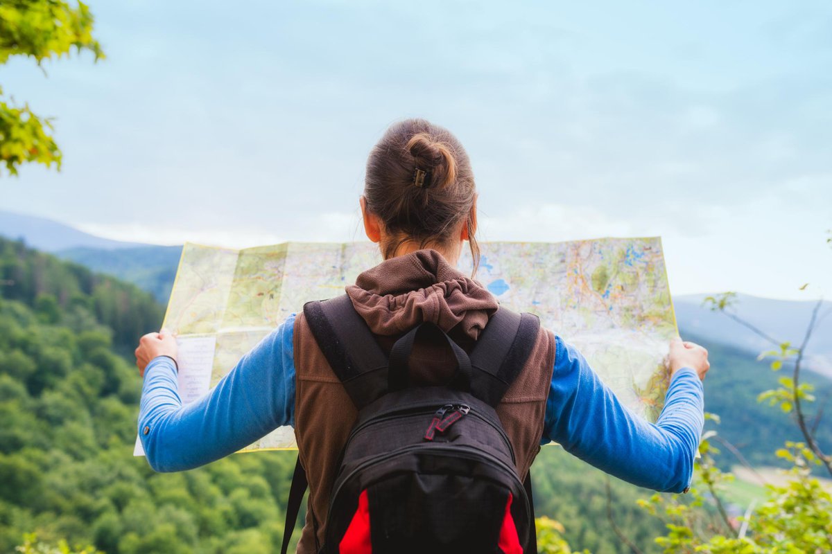 woman looking at a map while hiking in nature