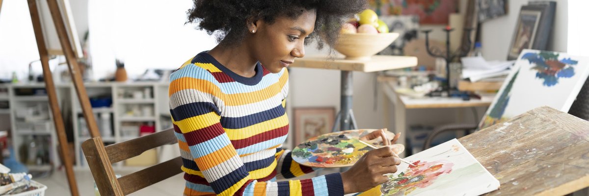 A woman painting in her home art studio.