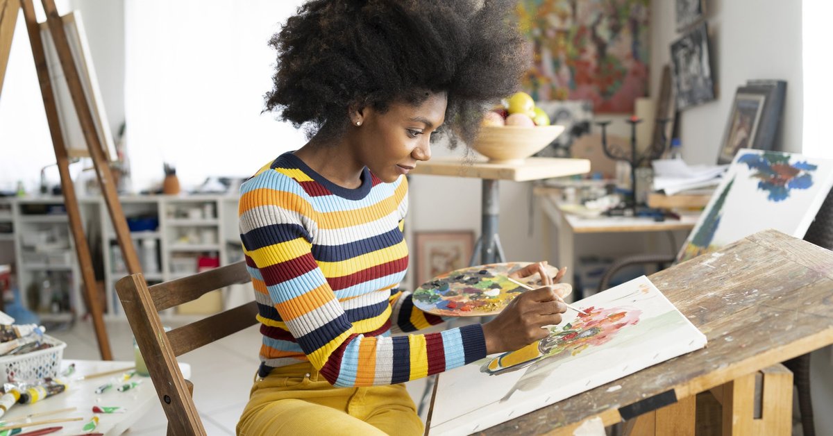 A woman painting in her home art studio.
