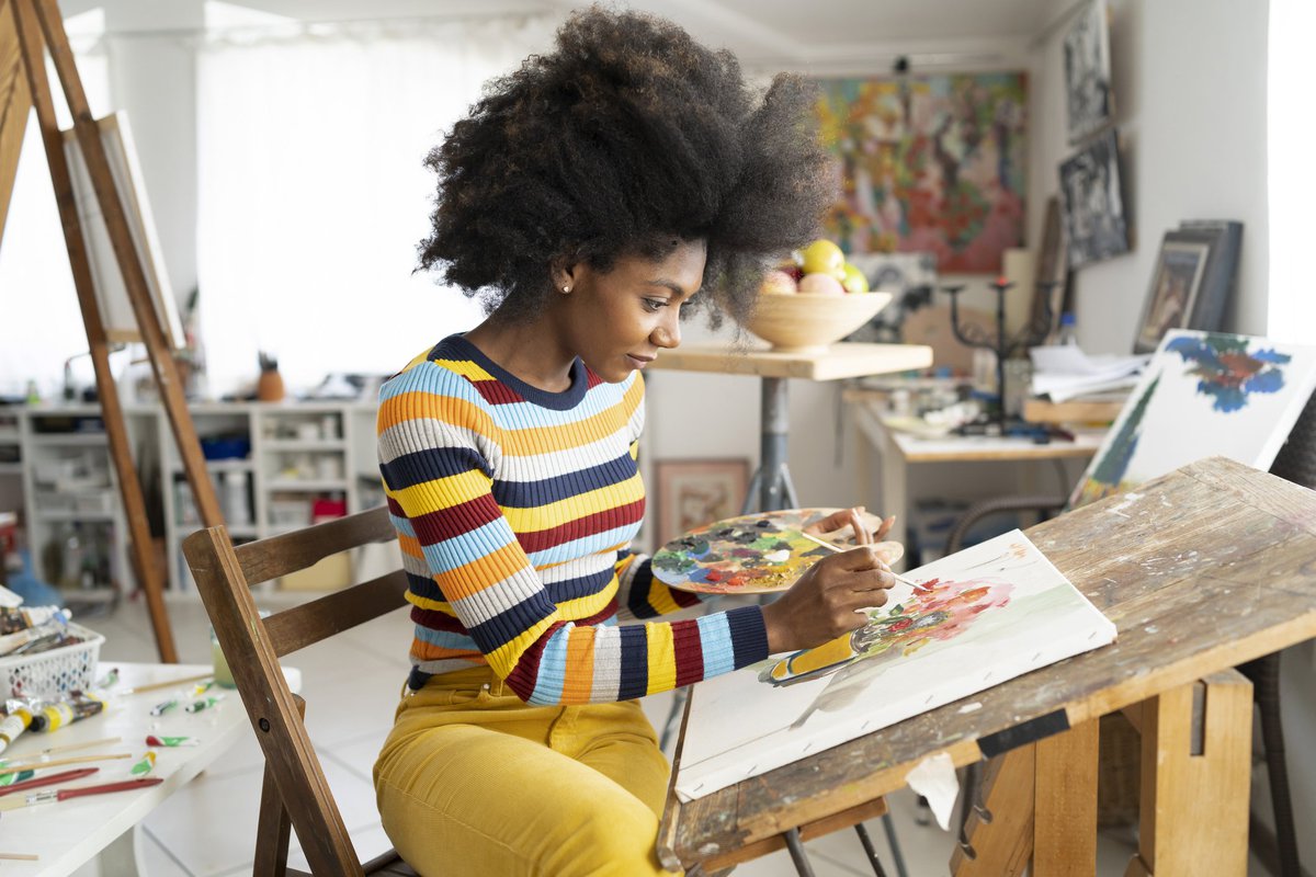 A woman painting in her home art studio.