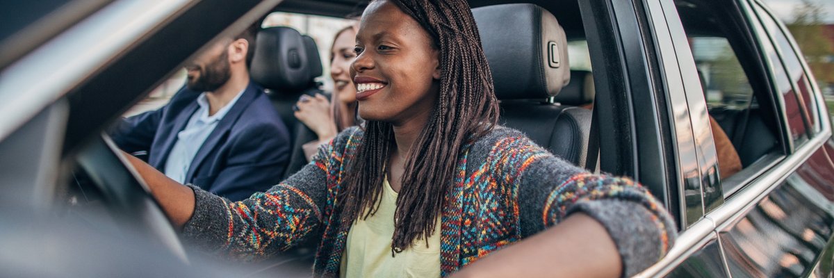 A woman driving a car with multiple passengers.