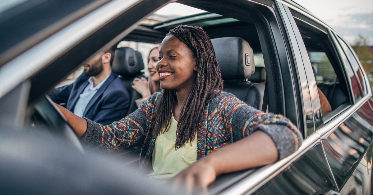 A woman driving a car with multiple passengers.