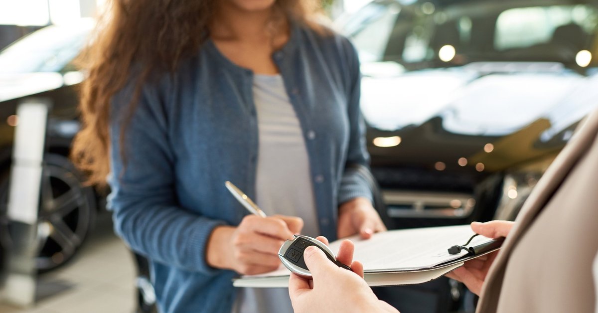 woman signing car paperwork