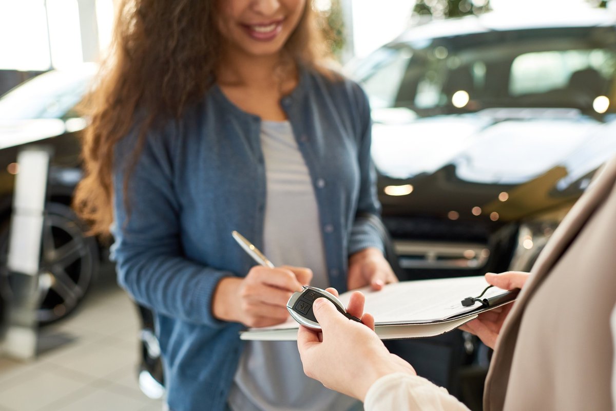 woman signing car paperwork