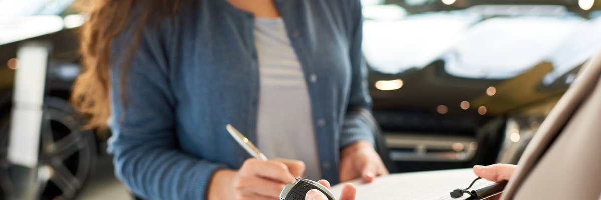 woman signing car paperwork