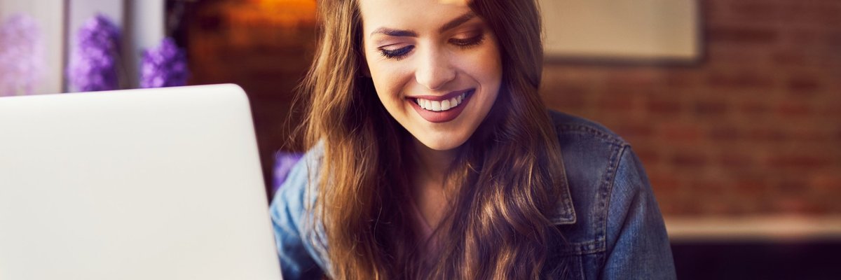 woman smiling with coffee and computer