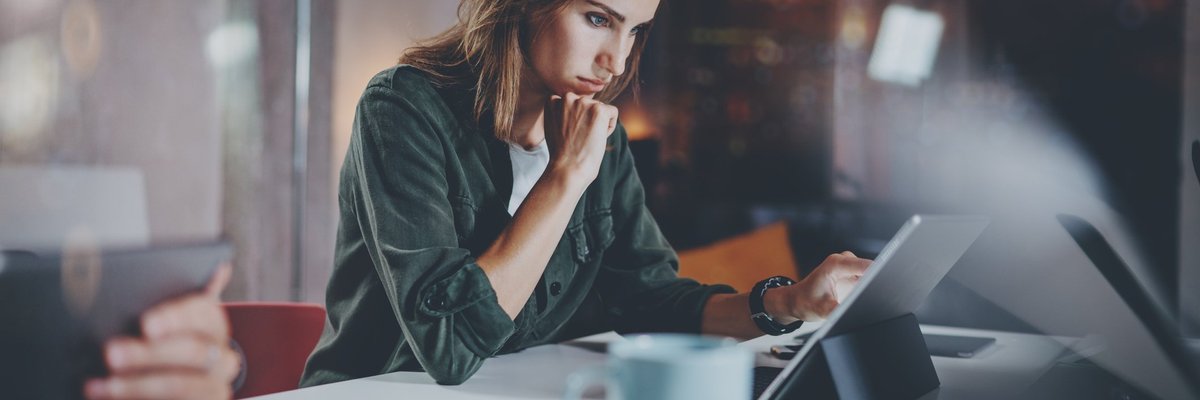 A woman reading on a tablet.