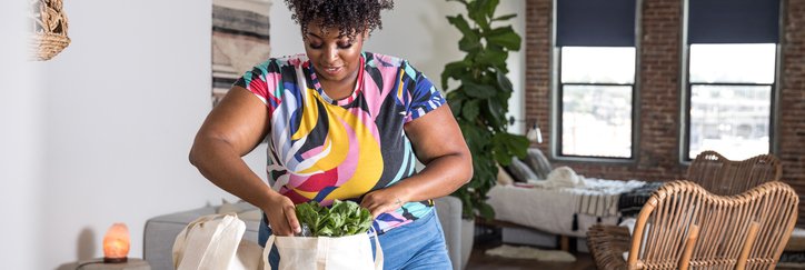 A woman unpacking grocery bags in her home.