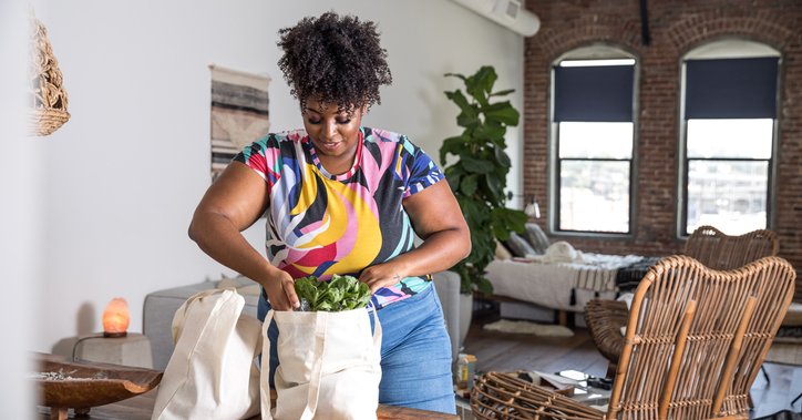 A woman unpacking grocery bags in her home.