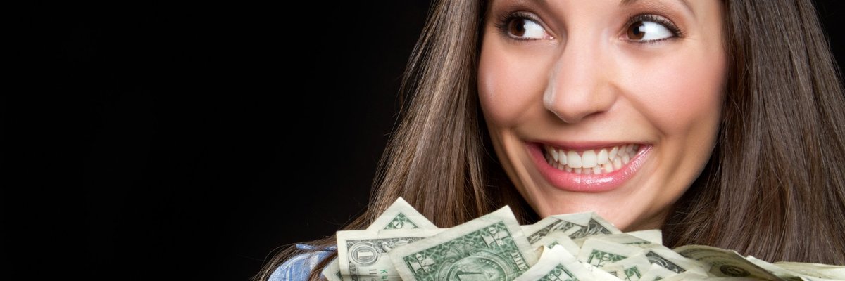 woman smiling and holding a large pile of cash