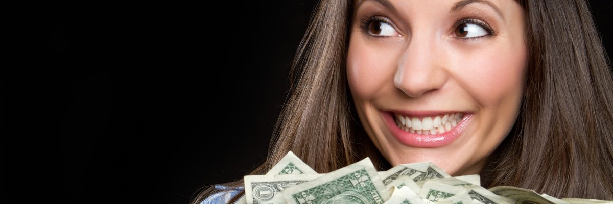 woman smiling and holding a large pile of cash