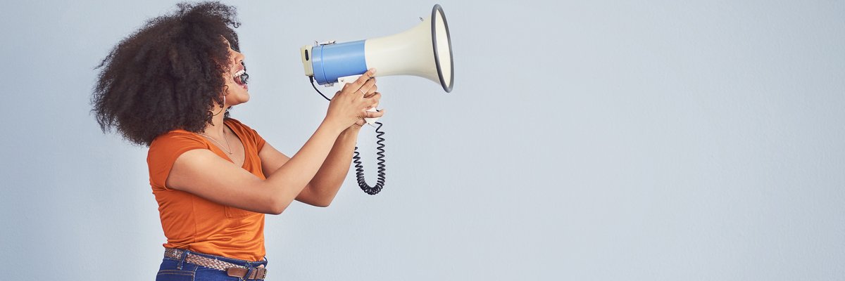 Woman holds up megaphone to make announcement.