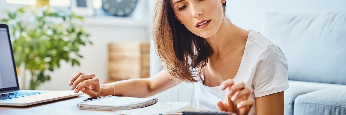 Woman uses a calculator at a desk