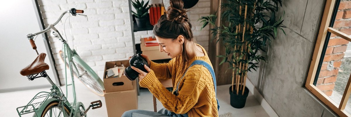 A woman taking photos of her bike and other items in her apartment.