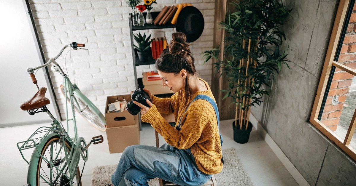 A woman taking photos of her bike and other items in her apartment.