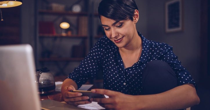 A woman with phone and computer.