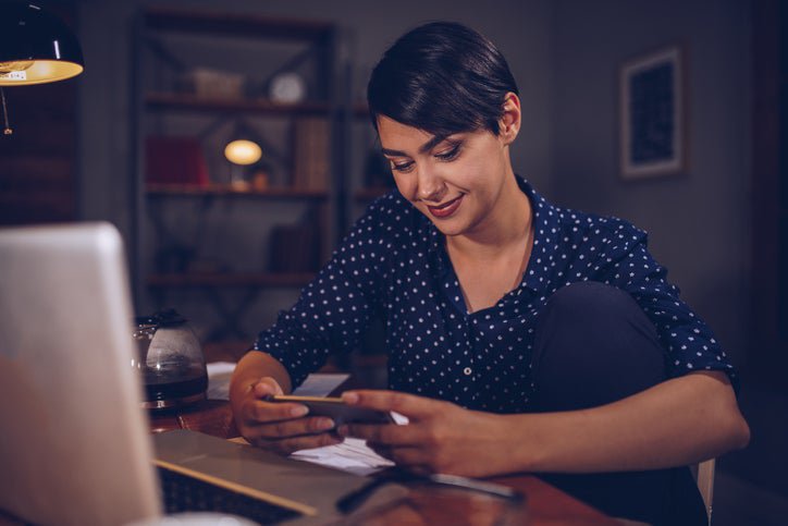 A woman with phone and computer.