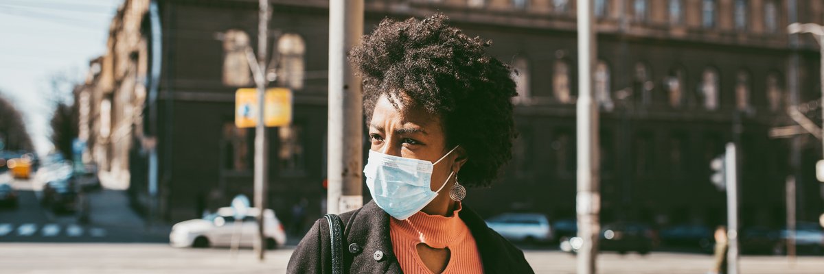 A woman wearing a medical mask walking down the street.