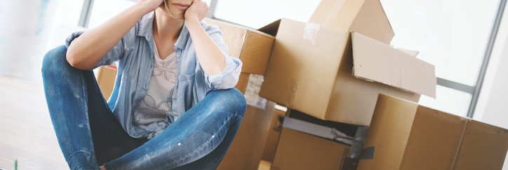 A tired woman with moving boxes.