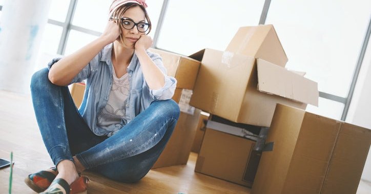 A tired woman with moving boxes.